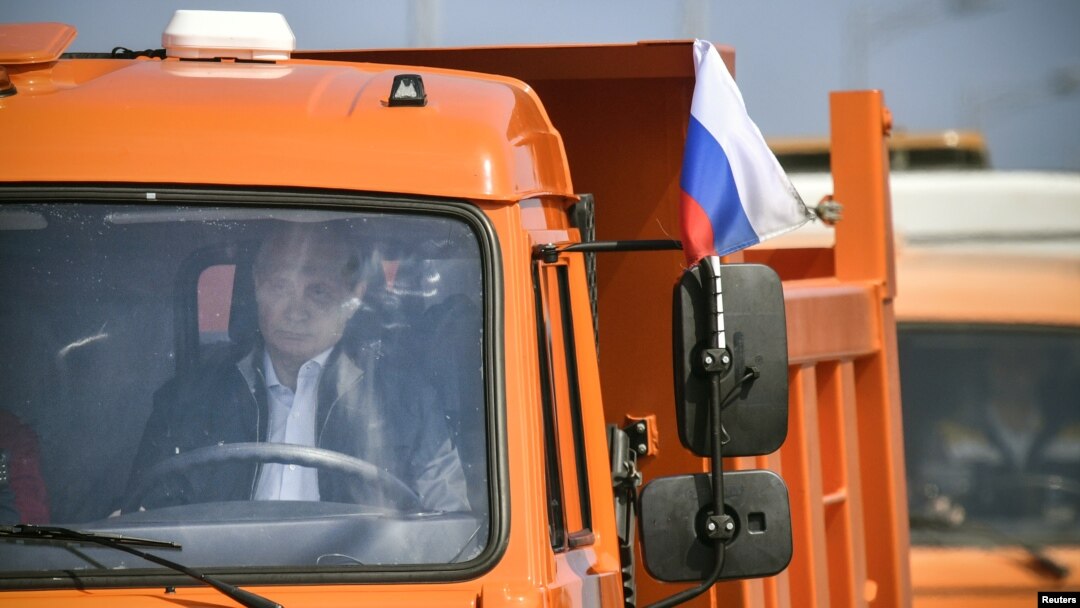 Presiden Rusia Vladimir Putin mengendari truk dalam upacara peresmian Jembatan Selat Kerch yang menghubungkan daratan Rusia dengan wilayah Krimea yang masih dalam sengketa, 15 Mei 2018.