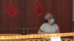 A woman wearing face masks to protect against the spread of the coronavirus lines up at a rapid coronavirus testing center after the COVID-19 alert raise to level 3 in Taipei, Taiwan, Tuesday, May 18, 2021. (AP Photo/Chiang Ying-ying)