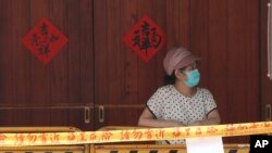 A woman wearing face masks to protect against the spread of the coronavirus lines up at a rapid coronavirus testing center after the COVID-19 alert raise to level 3 in Taipei, Taiwan, Tuesday, May 18, 2021. (AP Photo/Chiang Ying-ying)