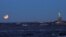 A "Super Blue Blood Moon" sets during a partial lunar eclipse next to the Statue of Liberty as it is seen from Brooklyn, in New York, Jan. 31, 2018. 