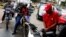 A gas station worker pumps gas into a motorcycle as people wait in line to fill the tanks of their vehicles at a gas station of the state oil company PDVSA in Caracas, Venezuela, March 22, 2017. 