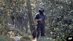 A state police stands guard at the site where at least 5 bodies were found in a clandestine grave on the outskirts of Mexico City, February 27, 2011