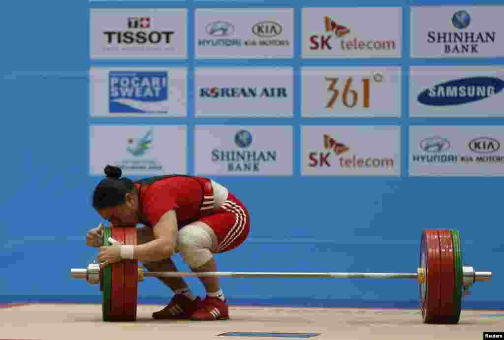 Kazakstan's Zhazira Zhapparkul kisses the weights after lifting 145kg on her third attempt in the women's clean and jerk 75kg weightlifting competition at the Moonlight Garden Venue during the 17th Asian Games in Incheon, South Korea. 