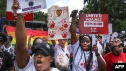 Activists gesture as they march through the Central Business District at a demonstration against an alarming rise in murders of young women in Nairobi on January 27, 2024.