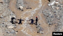 Civil defense members look for survivors after rain storms unleashed flash floods, near the Dead Sea, Jordan, Oct. 26, 2018. 