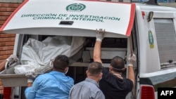Members of the police force unload the bodies of victims of a massacre allegedly at the hands of an armed groups in the Colombian municipality of Arauca, at the morgue in Arauca, near the Venezuelan border, on Aug. 22, 2020.