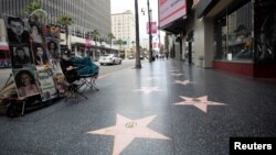 Venera Teimurazoa, seorang pelukis potret, menunggu pelanggan di Hollywood Boulevard saat pandemi virus corona (Covid-19) di Los Angeles, California, 18 Mei 2020. (Foto: Reuters)