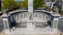 FILE - Traffic winds around the statue of Confederate President Jefferson Davis on Monument Avenue, April 7, 2020, in Richmond, Va.
