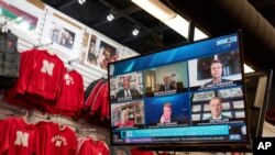 A Big Ten virtual news conference to discuss the reopening of the football season is seen on a television screen inside a Husker Hounds sports apparel store in Omaha, Neb., Sept. 16, 2020.