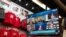 A Big Ten virtual news conference to discuss the reopening of the football season is seen on a television screen inside a Husker Hounds sports apparel store in Omaha, Neb., Sept. 16, 2020.