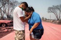 Dora Negrete is consoled consoled by her son Hector Rocha after seeing their destroyed mobile home at the Talent Mobile Estates, Sept. 10, 2020, in Talent, Ore., as wildfires devastate the region.