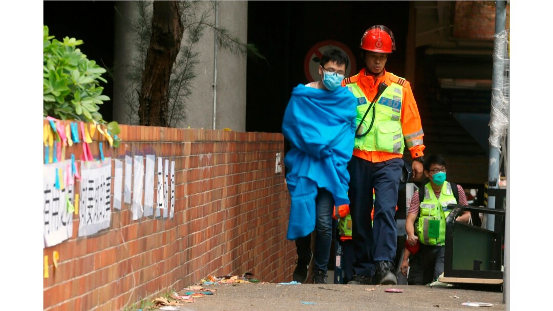 A medical worker walks with an injured protester at Hong Kong Polytechnic University in Hong Kong, Tuesday, Nov. 19, 2019. About 100 anti-government protesters remained holed up at the university Tuesday as a police siege of the campus entered its…