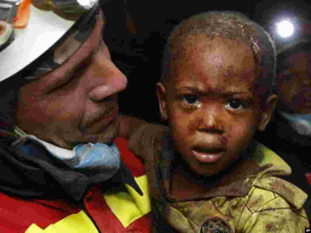 A Spanish rescuer carries two-year-old Redjeson Hausteen Claude after he was rescued from a collapsed home in the aftermath of the earthquake in Port-au-Prince, Thursday, Jan. 14, 2010. (AP Photo/Gerald Herbert)