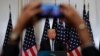 FILE - A reporter uses his mobile phone to record U.S. President Donald Trump at a news conference in New York, Sept. 26, 2018. A presidential wireless emergency alert system is planned for 2:18 p.m. EDT Wednesday. Some people are upset that they cannot opt out of the test, while others fear Trump will abuse the system.