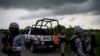 In this July 1, 2017 photo, Veracruz state police dismantle a road block in Coatzacoalcos, Mexico. Recent killings contrast with years of gangs hiding hits, recalling instead past drug wars, when criminal groups dumped piles of bodies as overt warning.