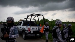 In this July 1, 2017 photo, Veracruz state police dismantle a road block in Coatzacoalcos, Mexico. Recent killings contrast with years of gangs hiding hits, recalling instead past drug wars, when criminal groups dumped piles of bodies as overt warning.