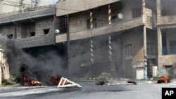 Burning tires and scattered roadblocks set by the anti-Syrian government protesters litter a street, following clashes between the security forces and protesters, in the southern city of Daraa, March 23, 2011