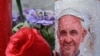 A candle depicting Pope Francis is placed at the statue of John Paul II outside the Gemelli hospital where Pope Francis is hospitalized in Rome on February 25, 2025.