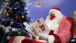 A postal worker dressed as Santa reads letters to addressed to 'Pere Noel' -- Father Christmas in French -- Nov. 23, 2020 in Libourne, France.