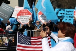 Aktivis Uighur dan pendukungnya melakukan unjuk rasa membela hak-hak Uighur di China, di seberang jalan dari markas besar PBB di New York City, 15 Maret 2018. (Foto: AP)