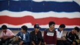 Cambodian migrant workers wait for document process as they prepare to migrate back to Cambodia at the Aranyaprathet Police station in Sa Kaew June 15, 2014.