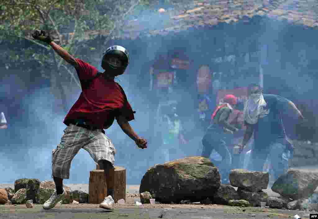 Residents of El Hatillo throw stones at riot police during a protest against the construction of a housing project on the outskirts of Tegucigalpa, Honduras, Sept. 17, 2019.