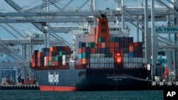 FILE- In this April 12, 2018, file photo, a container ship is unloaded at the Port of Oakland in Oakland, Calif. 