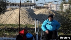 FILE - A disabled Palestinian waits for a travel permit to leave Gaza through Rafah border crossing after it was partially opened by Egyptian authorities, in Rafah, southern Gaza Strip, Jan. 29, 2019. 