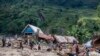 FILE - People walk next to houses destroyed by the floods in the village of Nyamukubi, South Kivu province, in Democratic Republic of Congo Saturday, May 6, 2023. Heavy rains triggered a landslide that killed at least 4 on December 24, 2023. 