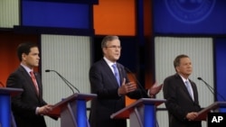 Jeb Bush, tengah, berbicara sementara Marco Rubio, kanan dan John Kasich mendengarkan saat debat utama bakal calon presiden AS dari Partai Republik di Des Moines, Iowa, 28 Januari 2016.