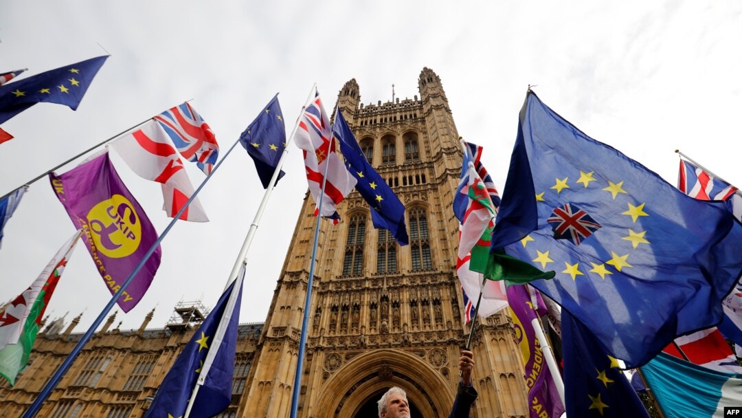 Para aktivis Brexit mengibarkan bendera Uni Eropa dan negara-negara anggotanya di luar gedung parlemen Inggris di London, 23 Oktober 2019. (Foto: dok).
