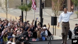 President Barack Obama waves during a Labor Day event at Detroit's Renaissance Center, headquarters of General Motors, in Detroit, Michigan, September 5, 2011.