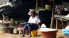 A girl sells food at a market in Beyla, Guinea, June 4, 2014. In a southeastern corner of Guinea, the Simandou mountain range rises above the forest. Under its slopes lies iron ore, a treasure long coveted by the world's miners. 