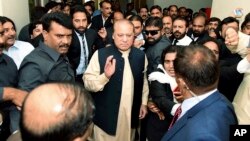 In this photo released by Pakistan Muslim League, Pakistani deposed Prime Minister Nawaz Sharif, center, arrives at an anti-corruption court in Islamabad, Pakistan, Tuesday, Sept. 26, 2017. 