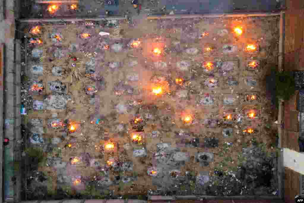 In this aerial picture burning pyres of victims who lost their lives due to the Covid-19 coronavirus are seen at a cremation ground in New Delhi, India.