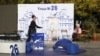 A woman walks past an open air reception of We continue the Change party, Oct. 24, 2024, in Sofia, as Bulgarians are called to cast ballots on Sunday in the seventh general elections in just over three years.