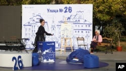 A woman walks past an open air reception of We continue the Change party, Oct. 24, 2024, in Sofia, as Bulgarians are called to cast ballots on Sunday in the seventh general elections in just over three years.