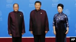 Philippine President Benigno Aquino III poses with Chinese President Xi Jinping who is hosting a welcome dinner for APEC leaders, and his wife Peng Liyuan, at the Beijing National Aquatics Center in Beijing, Monday, Nov. 10, 2014. (AP Photo/Ng Han Guan)