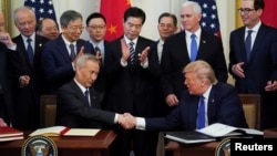 Presiden AS Donald Trump berjabat tangan dengan Wakil Perdana Menteri China Liu He usai menandatangani perjanjian dagang "tahap I" di Gedung Putih, Washington DC, Rabu (15/1). 