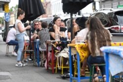 People are seen at a cafe after the state of Victoria saw COVID-19 case numbers drop in Melbourne, Nov. 17, 2020.