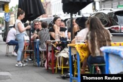 People are seen at a cafe after the state of Victoria saw COVID-19 case numbers drop in Melbourne, Nov. 17, 2020.