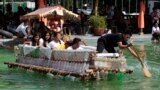 Filipinos paddle on a small boat they made with used plastic bottles and other recycled materials to join a boat-making competition in Manila, Philippines.