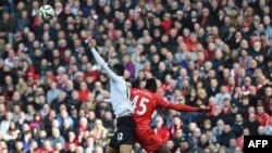 Pemain Liverpool Mario Balotelli (kanan) dan pemain Manchester United Chris Smalling dalam pertandingan Liga Premier di Liverpool (22/3). (AFP/Paul Ellis)