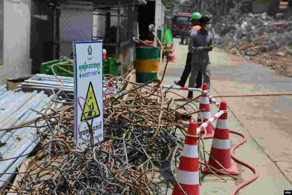 ស្លាក​សញ្ញា​«សុវត្ថិភាព»​ ក្នុង​បរិវេណ​វាយកម្ទេច​អគារប៊ូឌីញ​ រាជធានី​ភ្នំពេញ​ នាថ្ងៃទី៣ ខែ​សីហា ឆ្នាំ​២០១៧។​ ទាំង​កម្មករ​ និង​អ្នកថតរូប​តម្រូវ​ឱ្យ​ពាក់មួកការពារ​ និង​អាវសុវត្ថភាព​ជា​ចាំបាច់​ ដើម្បី​ចូលក្បែរ​អគារប៊ូឌីញ​ អំឡុង​ពេល​វាយកម្ទេច។ (រ៉ាវី សុភារ័ត្