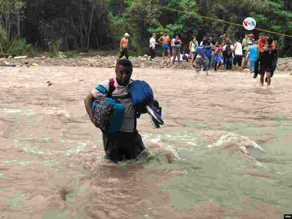 Un señor cruza con su equipaje el río Táchira, en la frontera entre Colombia y Venezuela, el martes, 2 de abril de 2019.