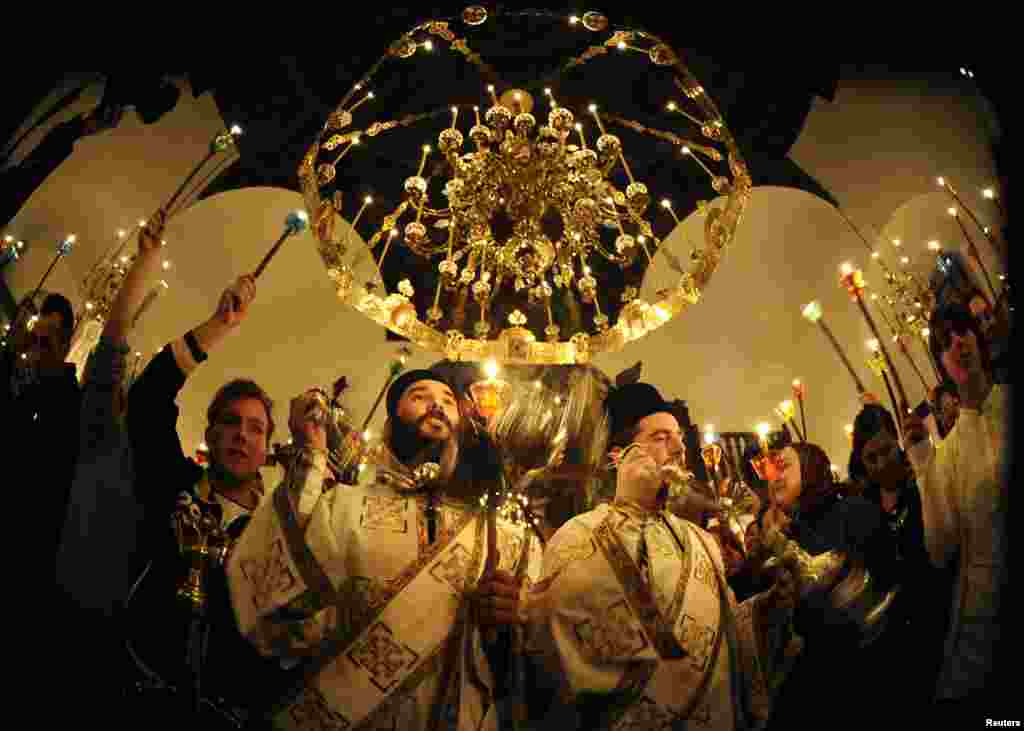 Priests lead the Christian Orthodox Easter service at the 10th century St. John the Baptist Monastery near Mavrovo, west of Macedonia's capital Skopje, April 20, 2014. REUTERS/Ognen Teofilovski (MACEDONIA - Tags: RELIGION) - RTR3LY73