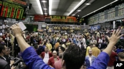 In this July 9, 2007 photo, traders in the S&P 500 Futures trading pit watch quote boards at the Chicago Mercantile Exchange in Chicago.