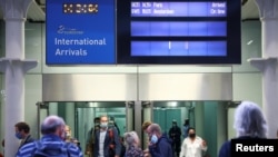 Travelers exit from an arrivals gate at St. Pancras International station following the arrival of a Eurostar train from Paris, amid the coronavirus pandemic, in London, Britain, July 30, 2021.