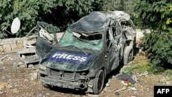 FILE - A destroyed car marked "Press" is seen at the site of an Israeli airstrike that targeted an area where a number of journalists were located in the southern Lebanese village of Hasbaya on Oct. 25, 2024.