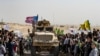 Syrian Kurds gather around a U.S. armored vehicle during a demonstration against Turkish threats on the outskirts of Ras al-Ain town in Syria's Hasakeh province near the Turkish border, Oct. 6, 2019.